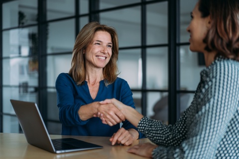 Businesswomen shaking hands in the office after discussing salary in Eswatini