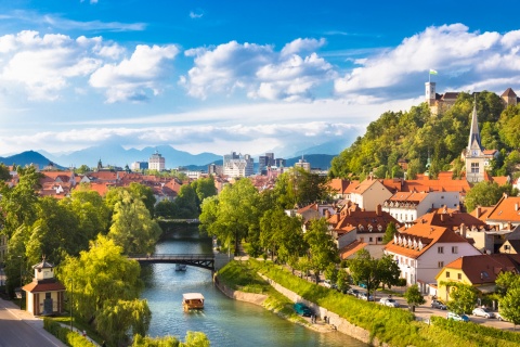 Panoramic view of Ljubljana Slovenia's river, forested hills, and old town