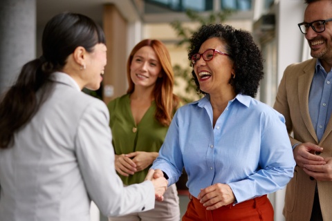 Diverse business colleagues shaking hands in a modern office