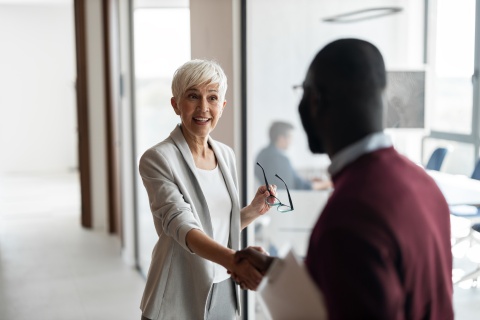 Handshake between senior woman and man in an office in Albania