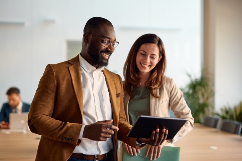 Smiling business people using a digital tablet in an office in Brunei