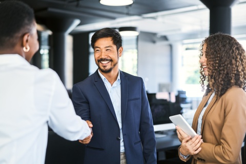 Smiling businessman shaking hands with colleague after discussing salary in Liberia