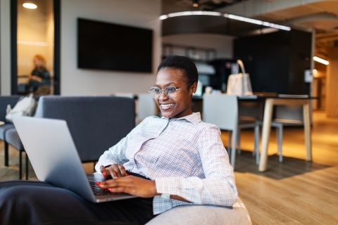 Young businesswoman using her laptop in a modern coworking space