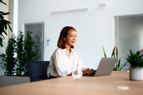 Young businesswoman working on laptop in modern office