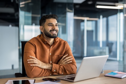 Businessman smiling and sitting at an office desk in Jordan