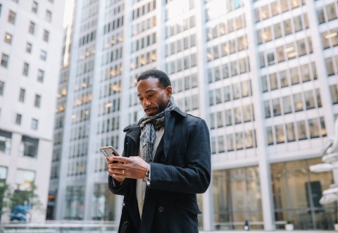 Businessman in Chile walking outdoors looking at his phone