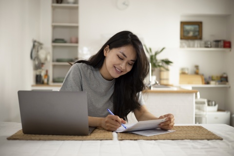 Smiling young woman working on payroll taxes in Lithuania