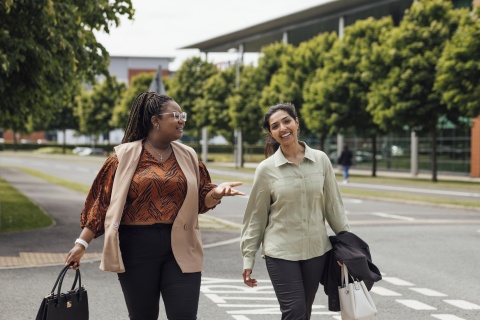 Two businesswomen walking and talking about salary in Kazakhstan