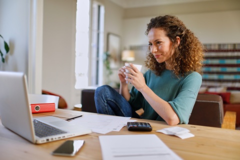 Woman in her home office holding a cup of coffee
