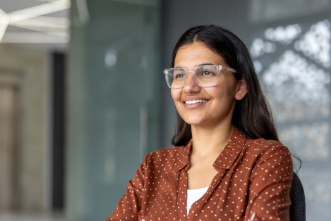 Woman with glasses smiling in an office in Jamaica