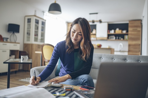 Young woman at home doing her payroll taxes in Guam