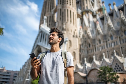 Adult male tourist with smartphone in Barcelona during a Spanish public holiday
