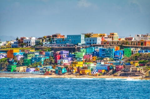 Bright colorful houses lining the hills overlooking the beach in San Juan, Puerto Rico