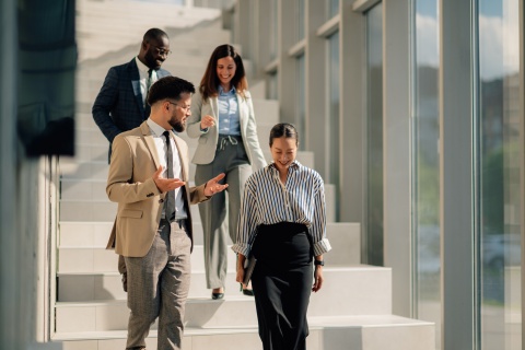 Businesspeople walking downstairs in modern office building
