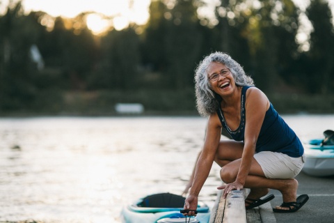Cheerful senior woman preparing to kayak on a river during a public holiday in Suriname