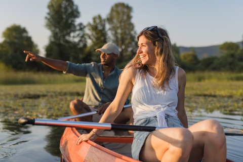 Couple canoeing on calm lake at sunset in Slovakia