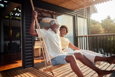 Couple laughing on a porch swing while celebrating a public holiday in Kenya