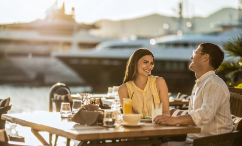 Happy couple sitting at a waterfront restaurant enjoying an Icelandic public holiday