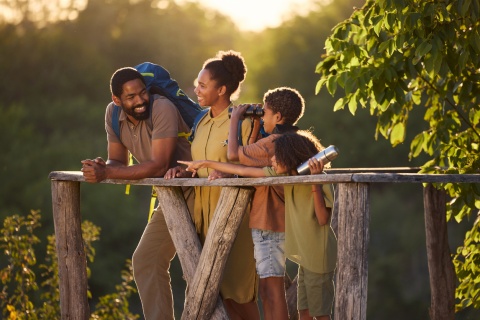 Happy family of hikers on a viewpoint at sunset during a Congo public holiday