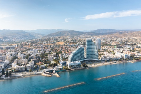 Limassol cityscape with modern architecture, coastline, and mountains