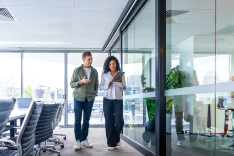 Man and woman walking and talking in an office