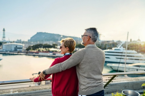 Mature couple on the terrace looking out at the harbor during a Polish public holiday