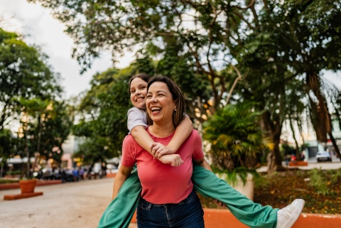 Mother giving her daughter a piggyback ride during Tanzania's public holidays