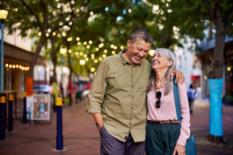 A smiling older couple walks together on a city street during a Pakistani public holiday