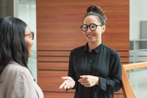 Smiling young businesswoman talking to her colleague about payroll taxes in Peru