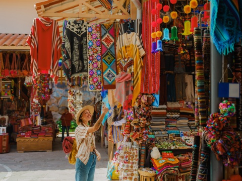Woman photographing with smartphone on Pisac Market in Peru
