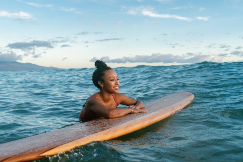 Surfer resting on her surfboard while enjoying Nicaragua’s public holidays