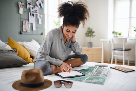 Young woman planning her Jordan public holiday at home with a map and tablet