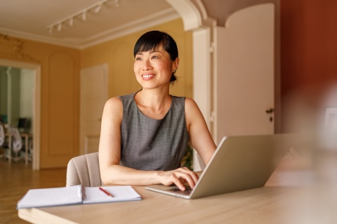 Businesswoman looking away while working on payroll taxes in Suriname