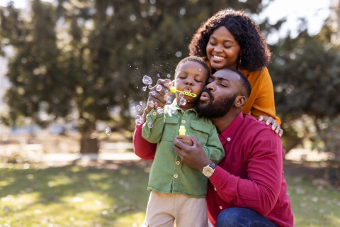Family blowing bubbles in a park during Belize’s public holidays
