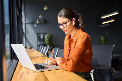 Female inventory analyst working on her laptop in an office