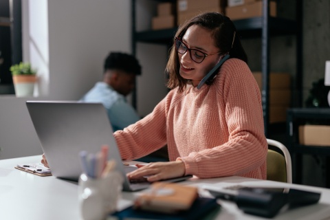Female logistics coordinator on the phone and working on a computer