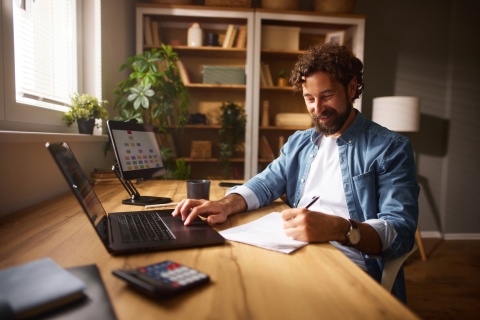 Male content strategist working from home and taking notes