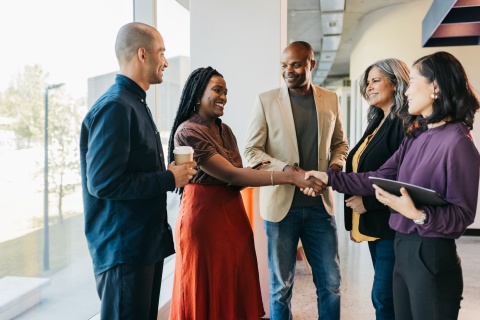 Multiracial business partners shaking hands in coworking business pace