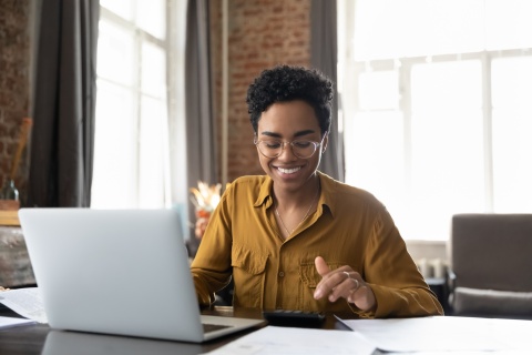Young entrepreneur woman in glasses calculating payroll taxes in Oman