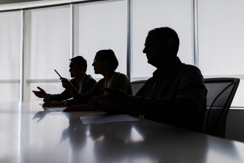 Lawyers sitting down in a meeting in dark room