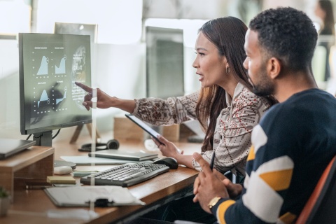 man and woman looking at computer screen