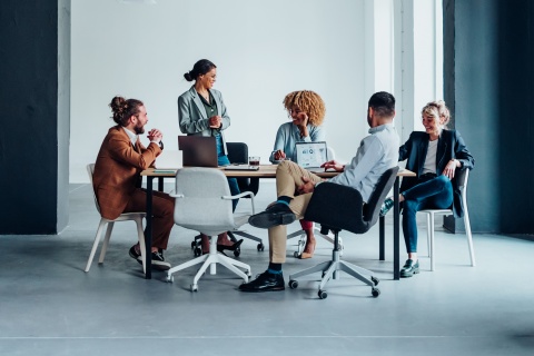 Colleagues collaborating in an office, organizing remote team-building activities.