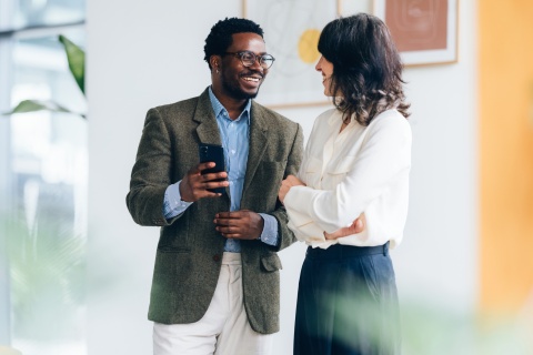 Two colleagues discussing staff augmentation during a friendly conversation in the office.