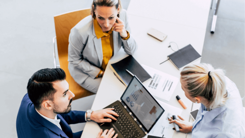 three employees working around a table